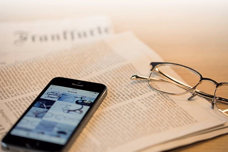 Lunorbrille auf Zeitung mit Smartphone Blaulicht.